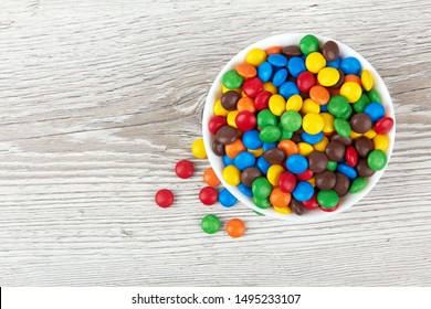 botones de chocolate coloridos sobre un fondo de madera