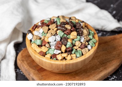 Colorful chocolate candy stones. Stone chocolate dragee in wooden bowl on dark background. Small multi-colored candies. Close up - Powered by Shutterstock