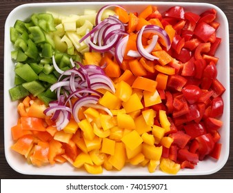 Colorful, chopped peppers in a ceramic dish.