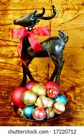 Colorful Chrismtas Tree Ornaments In A Bowl With A Reindeer Behind