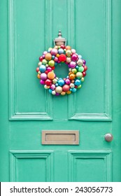 A Colorful Christmas Wreath On A Green Front Door