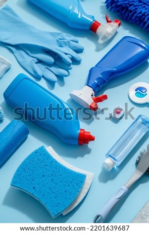 Colorful cleaning products on plain blue background. Housecleaning concept
