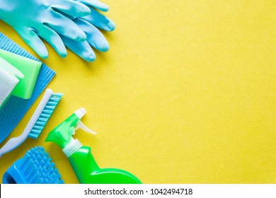 Colorful cleaning set for different surfaces in kitchen, bathroom and other rooms. Empty place for text or logo on yellow background. Cleaning service concept. Early spring regular clean up. Top view. - Powered by Shutterstock