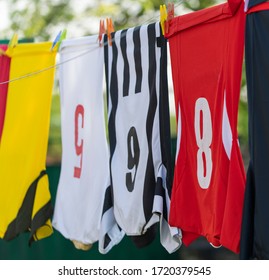 Colorful clothes hanging to dry on a laundry line. Football jerseys - Powered by Shutterstock