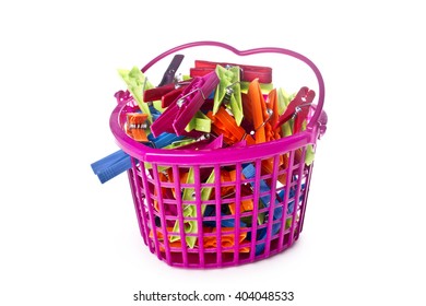 Colorful clothes pegs and orange plastic basket