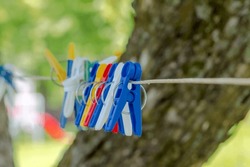 Colorful Clothespins Hanging On A Laundry Drying Line. Plastic Clothespins In Different Colors For Washing - Hanging On A Line .