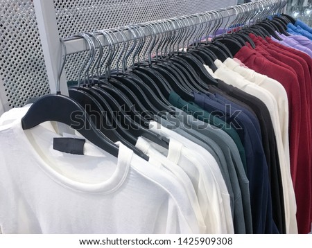 colorful clothing, sweater ,shirts set of on the racks in clothing store
