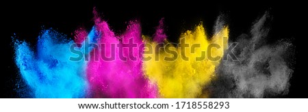colorful CMYK cyan magenta yellow key holi paint color powder explosion isolated on dark black background. printing print business industry manufacturing  beautiful party festival concept