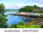 Colorful coastal fishing village of Portree, Isle of Skye, Scotland. Looking over the boat filled harbor at dusk.