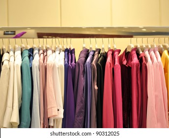 Colorful Collection Of Women's Clothes Hanging On A Rack.