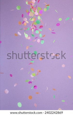 Colorful confetti falling, abstract. Cool colors: blue, purple and aqua. Carnival party background concept, space for text. Vertical orientation. rain.