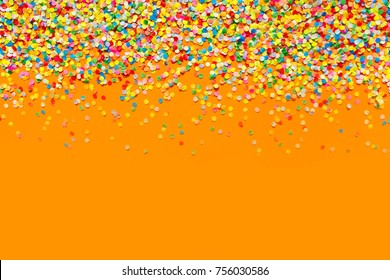 Colorful Confetti In Front Of Orange Background. 