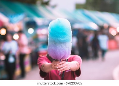 colorful cotton candy in the hand bleary background.