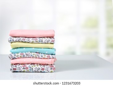 Colorful Cotton Folded Clothes Stack On White Table Empty Space Background,baby Laundry.