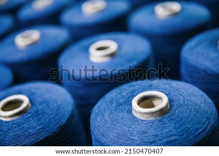 Colorful cotton yarns or threads on spool tube bobbins at cotton yarn factory.