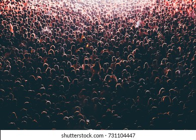 Colorful crowd of people of a big music festival in a stage lights as a beautiful background