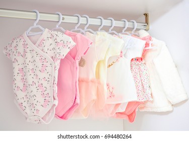 Colorful, cute girl baby dresses hanging on rack in wardrobe. Baby fashion concept design. - Shutterstock ID 694480264