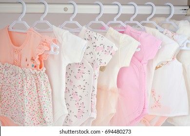Colorful, cute girl baby dresses hanging on rack in wardrobe. Baby fashion concept design. Wardrobe for newborn or toddler kids. - Shutterstock ID 694480273