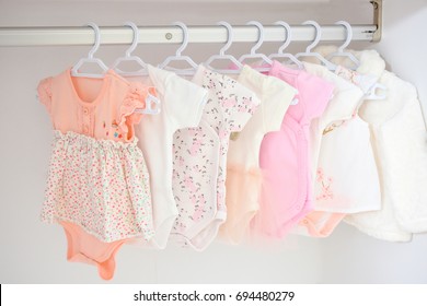 Colorful, cute girl baby dresses hanging on rack in wardrobe. Baby fashion concept design. - Shutterstock ID 694480279