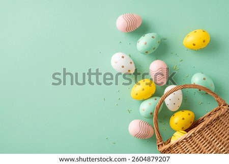 Colorful decorated Easter eggs placed near a wicker basket on a green surface, embodying the festive and joyful vibe of Easter celebrations