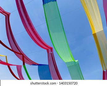 Colorful Decorative Fabrics Hanging In The Bright Blue Sky. Outdoor Event Decoration.