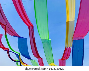 Colorful Decorative Fabrics Hanging In The Bright Blue Sky. Outdoor Event Decoration.