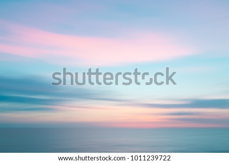 Colorful defocused sunset sky and ocean nature background with blurred panning motion.