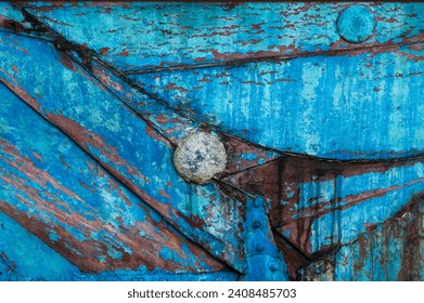 Colorful detail of peeling paint on the side of a sailboat. Abstract view of a distressed boat needing a good sanding but makes for a great background. 