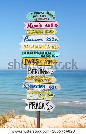 Colorful directions signs on the beach to different places of the world. Travel concept.