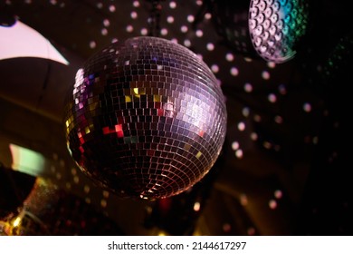 Colorful disco mirror ball lights night club background. Party lights disco ball. Selective focus. - Shutterstock ID 2144617297