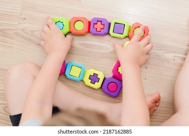 Colorful domino shapes game. Childs hand on part, connecting puzzle pieces. Montessori type educating toy. Fine motor skils. Kid Sense Child Development. - Shutterstock ID 2187162885