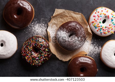Colorful donuts on stone table. Top view