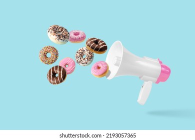 Colorful donuts with White-Pink megaphone on a pastel blue background. Creative minimal food concept. - Powered by Shutterstock