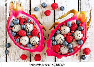 Colorful dragon fruit salads with raspberries and blueberries over a white wood background - Powered by Shutterstock