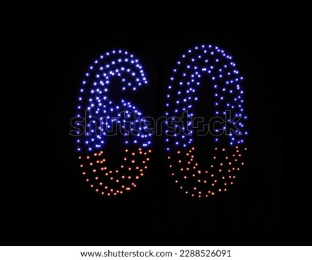 Colorful drone light shows on black night sky background. A figure of the number sixty, six, zerro, 60 made of glowing drones.