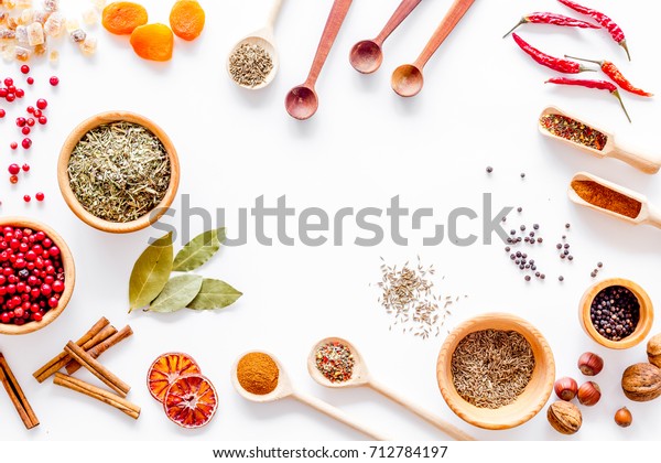 Colorful dry herbs and\
spices for cooking food white kitchen table background top view\
space for text