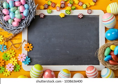 Colorful Easter Background With Eggs And Flower Decorations Symbolising Spring Around A Blank School Slate With Copy Space For Your Seasonal Greeting