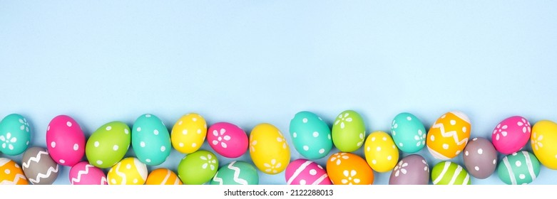 Colorful Easter Egg bottom border over a pastel blue paper banner background. Copy space. - Powered by Shutterstock