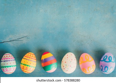 Colorful easter egg on blue pastel color wood background with space.
