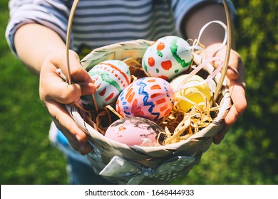 Colorful Easter eggs in basket  Children gathering painted decoration eggs in spring park  Kids hunt for egg outdoors  Festive family traditional play game Easter 