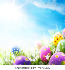 Colorful Easter eggs decorated with flowers in the grass on blue sky background