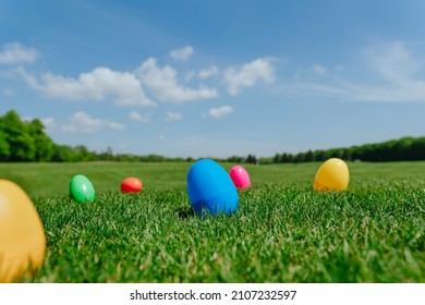 Colorful Easter eggs lying on the green grass outdoor. Easter holiday tradition for children of picking up the eggs. Selective focus.