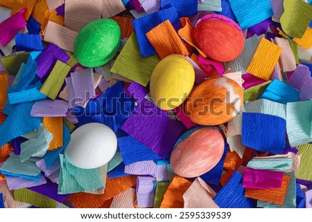 Colorful Easter eggs on a background of bright crepe paper strips