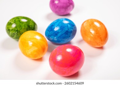Colorful Easter eggs on table for celebration of catholic Easter in april, copy space, on white, painted chicken eggs
