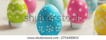 Colorful Easter eggs with patterns sit on a soft surface. Each egg has unique designs like polka dots or zigzags. The scene feels cheerful and festive. Great for greeting cards, ads. Banner