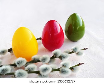 Colorful Easter eggs with pussy willow branches on light background