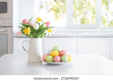 Colorful Easter eggs and spring flowers on white table on modern kitchen interior background