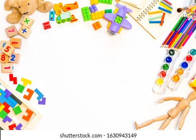 Colorful Educational Toys And School Supplies On A White Background. Frame Of Folding Wooden Blocks, Cars, Pencils, Paints.Background For Preschool And Kindergarten Or Art Classes. Flat Lay.Copy Space