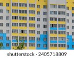 It is colorful European apartment building in a sunny day. It is multicolored city buildig. There are clouds in blue sky. It is a close up view