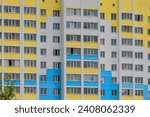 It is colorful European apartment building in a sunny day. It is multicolored city buildig. There are clouds in a blue sky. It is close up view
